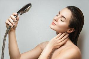 Beautiful sensual woman washing under shower spray photo