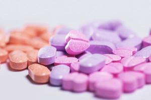 Closeup shot of a pile of colorful pills on white background. photo