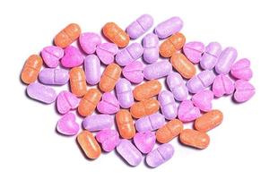 Closeup shot of a pile of colorful pills on white background. photo