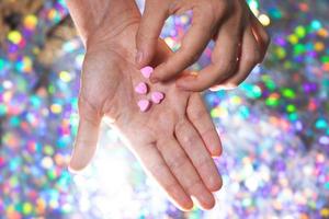 hombre tomando una de las pastillas en forma de corazón de la palma. foto