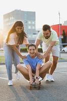 diversos amigos despreocupados divirtiéndose y montando longboard en el estacionamiento foto