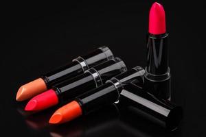 Colorful lipsticks on black photo
