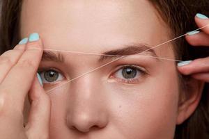 Eyebrow correction with a white thread photo