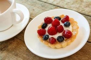 pastel con bayas y taza de café foto