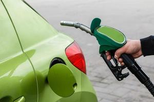 Man fills up his car with a gasoline photo