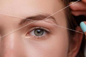 Eyebrow correction with a white thread photo