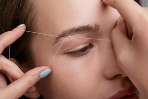 Eyebrow correction with a white thread photo