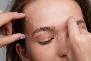 Eyebrow correction with a white thread photo