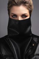 Portrait of stylish woman wearing leather neck gaiter instead of prevention mask. photo