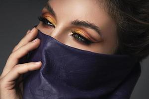 Portrait of stylish woman wearing leather neck gaiter instead of prevention mask. photo
