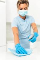 Woman worker wearing prevention mask and gloves during apartment cleaning photo