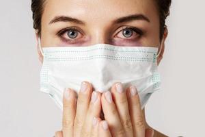 Young caucasian woman with virus symptoms wearing prevention mask photo