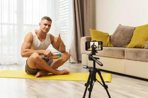 Fitness blogger streaming or recording video for his subscribers photo