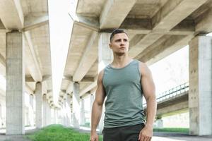 Young athletic man wearing sportswear after his street workout photo