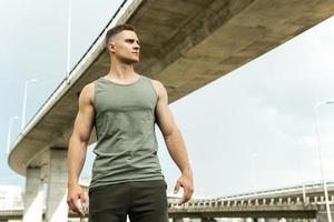 Young athletic man wearing khaki sportswear after his street workout photo