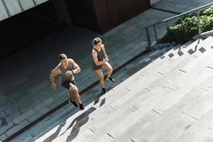 Sportive couple during workout stair running outdoors photo