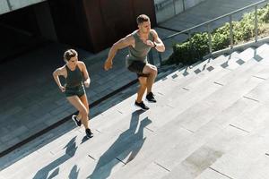 Sportive couple during workout stair running outdoors photo