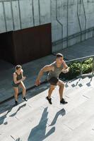 pareja deportiva durante la escalera de entrenamiento corriendo al aire libre foto