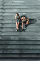 pareja atlética sentada en una escalera de hormigón después de trotar o hacer ejercicio al aire libre foto