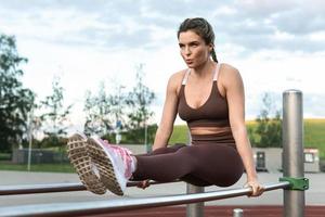 mujer atleta durante el entrenamiento de calistenia en barras paralelas foto