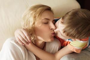 Lovely mother and son kissing her at home photo