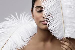 mujer india joven y sensual con una suave pluma de avestruz foto