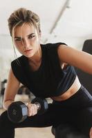 Athletic woman doing bicep curl exercise with a dumbbells in the gym photo