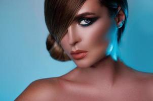 Model in stylish image with sleek hair covering one eye and beautiful green eyeshadows on another photo