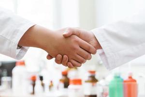 Handshake doctors or scientists against blurred background photo