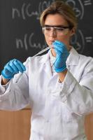 Scientist is using dropper and test tube in a laboratory during research photo