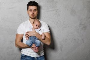 Young loving father holding his cute little baby boy photo