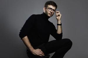 Young intelligent man wearing turtleneck and eyeglasses photo