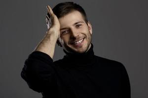 Forgetful smiling man against dark gray background photo