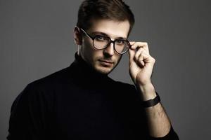 Young intelligent man wearing turtleneck and eyeglasses photo