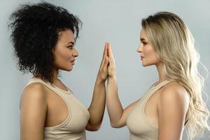Portrait of Caucasian and African American women on gray background. photo