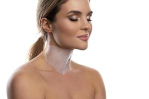 Woman with a moisturizing and anti aging sheet mask applied on her neck photo