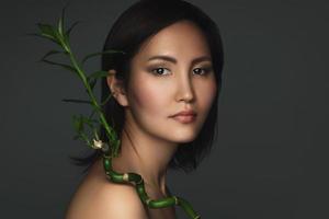 Beautiful asian woman with a bamboo plant in her hands photo