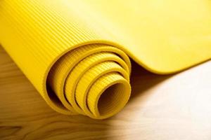 Close-up of yellow fitness mat on the floor photo