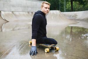 Young handicapped guy with a longboard in a skatepark photo