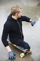 Young handicapped guy with a longboard in a skatepark photo