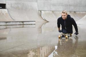 Young handicapped guy with a longboard in a skatepark photo