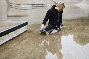 Young handicapped guy with a longboard in a skatepark photo