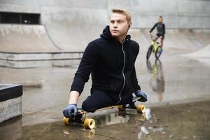 Young handicapped guy with a longboard in a skatepark photo