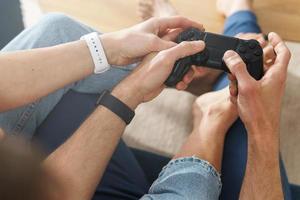 Couple with a gamepads are playing video game console photo