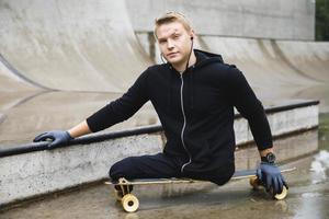 Young handicapped guy with a longboard in a skatepark photo