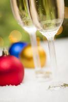 Christmas Ornaments and Champagne Glasses on Snow photo