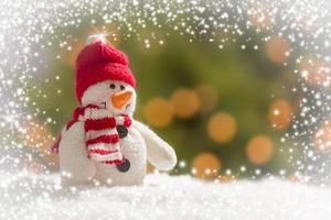Cute Snowman Over Abstract Snow and Light Background photo