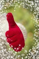 Woman Wearing Red Mittens Holding Out Thumbs Up Hand Sign photo