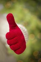 Woman Wearing Red Mittens Holding Out Thumbs Up Hand Sign photo