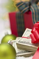 Stack of Hundred Dollar Bills with Bow Near Christmas Ornaments photo